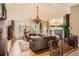 Spacious living room with hardwood floors, large windows, a chandelier, and comfortable seating, perfect for relaxation at 24860 N Mountain Park Dr, Evergreen, CO 80439