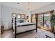 Relaxing main bedroom boasts a stylish chandelier, plush carpet, and private deck access with scenic views at 24860 N Mountain Park Dr, Evergreen, CO 80439