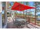 Enjoy this outdoor deck with a large dining table under a striking red umbrella, perfect for alfresco dining at 24860 N Mountain Park Dr, Evergreen, CO 80439