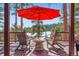 Enjoy scenic views from this deck featuring outdoor seating and a red umbrella for comfortable relaxation at 24860 N Mountain Park Dr, Evergreen, CO 80439