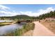 Scenic view of a small bridge over a pond surrounded by trees and vegetation at 24860 N Mountain Park Dr, Evergreen, CO 80439