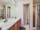 Bright bathroom featuring double sinks, large mirror, and a walk-in shower at 3859 Rawhide Cir, Castle Rock, CO 80104