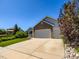 Two-story home featuring a three-car garage with a long driveway at 3859 Rawhide Cir, Castle Rock, CO 80104