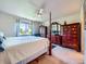 Spacious main bedroom with a four-poster bed, lots of natural light, and beautiful matching wood furniture at 3859 Rawhide Cir, Castle Rock, CO 80104