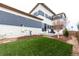 Backyard with green turf features patio with Adirondack chairs next to home at 9791 Dunning Cir, Highlands Ranch, CO 80126