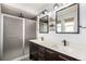 Stylish bathroom featuring double sinks, modern fixtures, and a walk-in shower with glass door at 9791 Dunning Cir, Highlands Ranch, CO 80126