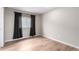 Neutral bedroom showcasing wood-look floors and a window with dark drapes at 9791 Dunning Cir, Highlands Ranch, CO 80126