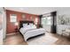 Comfortable bedroom with a large bed, wooden floors, stylish decorations, and natural light at 9791 Dunning Cir, Highlands Ranch, CO 80126