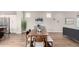 Elegant dining area with a large wooden table, modern decor, and seamless transitions to the kitchen and living room at 9791 Dunning Cir, Highlands Ranch, CO 80126