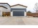 Exterior shot of the garage showing navy blue overhead door and stone address numbers at 9791 Dunning Cir, Highlands Ranch, CO 80126