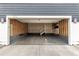 Two-car garage with concrete floor and unfinished walls offers open shelving at 9791 Dunning Cir, Highlands Ranch, CO 80126