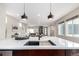 Kitchen island features a modern sink, barstool seating, and open floorplan to the connected living spaces at 9791 Dunning Cir, Highlands Ranch, CO 80126