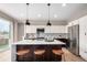 Kitchen with quartz countertop island, black pendant lights, stainless steel appliances, and modern backsplash at 9791 Dunning Cir, Highlands Ranch, CO 80126
