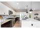 Bright kitchen featuring a quartz island, modern stainless steel appliances, and dark hardwood floors at 9791 Dunning Cir, Highlands Ranch, CO 80126