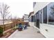 Back patio features blue Adirondack chairs, a fire pit and mature landscaping at 9791 Dunning Cir, Highlands Ranch, CO 80126