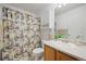 Traditional bathroom features a floral shower curtain, a white vanity with a solid surface top and a mirrored wall cabinet at 11753 Elizabeth Cir, Thornton, CO 80233