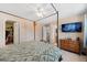 Comfortable bedroom with a four-poster bed, ceiling fan, and connected bath and closet at 11753 Elizabeth Cir, Thornton, CO 80233