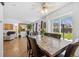 Open dining room features a wooden floor, ceiling fan, and view into the living room and backyard at 11753 Elizabeth Cir, Thornton, CO 80233