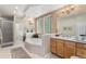 Brightly lit bathroom with a soaking tub, glass block window and shower, and double vanity at 11422 W Cooper Ave, Littleton, CO 80127