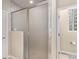 This bathroom features a glass block window, a large glass enclosed shower and a toilet at 11422 W Cooper Ave, Littleton, CO 80127