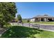 View of house with partial stone exterior, well-kept lawn and partial view of a golf course on a sunny day at 11422 W Cooper Ave, Littleton, CO 80127