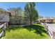 Well-kept front yard with green grass, mature trees, and a wooden fence, enhancing the home's curb appeal at 11422 W Cooper Ave, Littleton, CO 80127