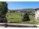 Scenic golf course view from the home's backyard featuring lush greens and distant buildings on a clear day at 11422 W Cooper Ave, Littleton, CO 80127