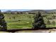 Scenic golf course view from backyard of the home, featuring lush green landscaping and distant buildings at 11422 W Cooper Ave, Littleton, CO 80127