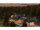 A charming home nestled among tall trees, illuminated by warm, inviting lights, with a picturesque landscape at 30886 County Road 17/21, Elizabeth, CO 80107