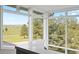Bright sunroom showcasing natural light from large windows and views of a green field with trees at 30886 County Road 17/21, Elizabeth, CO 80107