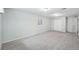 Spacious carpeted basement area with a window, closet doors, and access to additional rooms at 5540 E Jewell Ave, Denver, CO 80222
