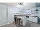 Basement bar area with two stools, custom shelving, and carpeted floors at 5540 E Jewell Ave, Denver, CO 80222