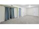 Basement bedroom with neutral paint, soft carpet, and closet with a stylish blue curtain at 5540 E Jewell Ave, Denver, CO 80222