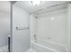 Clean bathroom with a white tiled shower, showerhead, grab bar, and towel bar at 5540 E Jewell Ave, Denver, CO 80222