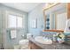 Bathroom with granite vanity, decorative mirror, and natural light from window at 5540 E Jewell Ave, Denver, CO 80222