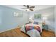 Bright bedroom with a ceiling fan, wood floors, and bright light from two windows at 5540 E Jewell Ave, Denver, CO 80222