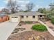 Charming single-story home featuring a well-manicured front yard with stone walkway at 5540 E Jewell Ave, Denver, CO 80222