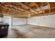 Large garage with high ceilings, concrete floor, overhead lighting, and roll up door at 5540 E Jewell Ave, Denver, CO 80222