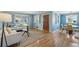 Bright living room with hardwood floors, featuring a front door, dining area, and ample natural light at 5540 E Jewell Ave, Denver, CO 80222