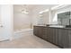 Bright bathroom featuring double vanity and soaking tub at 942 S Fulton St, Aurora, CO 80247