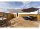 Outdoor patio with wooden tile flooring, comfortable seating, and an umbrella for shade at 942 S Fulton St, Aurora, CO 80247