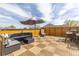 Relaxing rooftop deck with comfortable seating, an umbrella, and a wooden privacy fence at 942 S Fulton St, Aurora, CO 80247