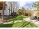 Manicured backyard boasts a lush green lawn and a contemporary seating area with a firepit at 942 S Fulton St, Denver, CO 80247