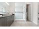 Bathroom with stylish modern vanity and glass enclosed shower with white and gray tiling at 942 S Fulton St, Denver, CO 80247