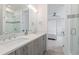 Bathroom featuring a modern vanity, a large mirror, and a glass-enclosed shower at 942 S Fulton St, Denver, CO 80247