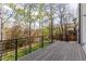 A wooden deck features black railings and views of foliage and trees and a greenbelt at 942 S Fulton St, Denver, CO 80247
