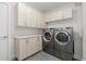 Organized laundry room with washer, dryer, and lots of storage cabinets at 942 S Fulton St, Denver, CO 80247