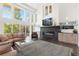 Bright living room with a stone fireplace, high ceilings, large windows, and a comfortable seating area, perfect for relaxation at 942 S Fulton St, Denver, CO 80247