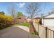 Spacious backyard with a concrete patio, mature trees, and a grassy area, perfect for outdoor gatherings at 1454 Utica St, Denver, CO 80204