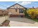Brick home with an extended driveway and mature landscaping offers a welcoming curb appeal at 1454 Utica St, Denver, CO 80204
